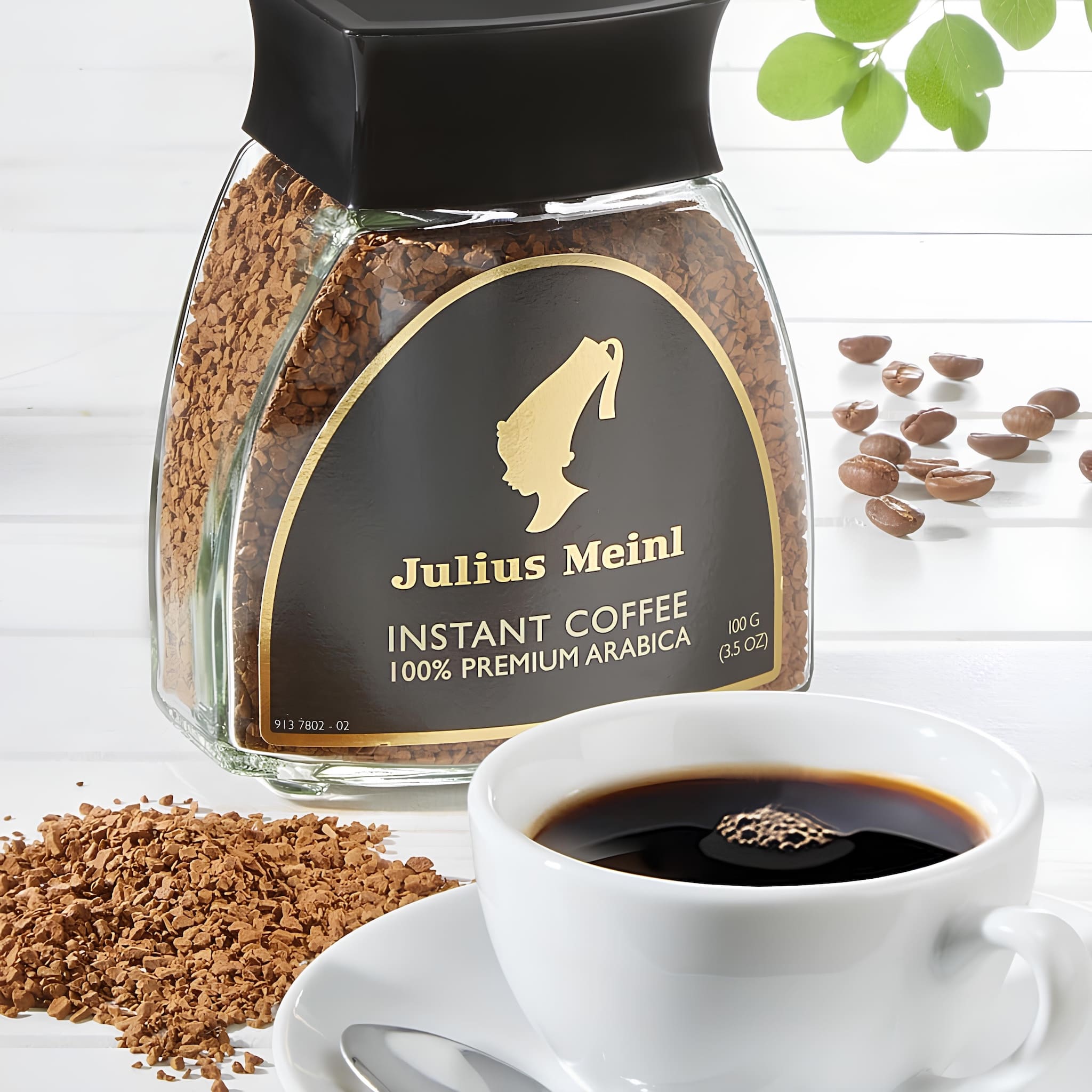 julius meinl instant kávé üvegben mellett csésze frissen főzött kávé, kávéval a háttérben